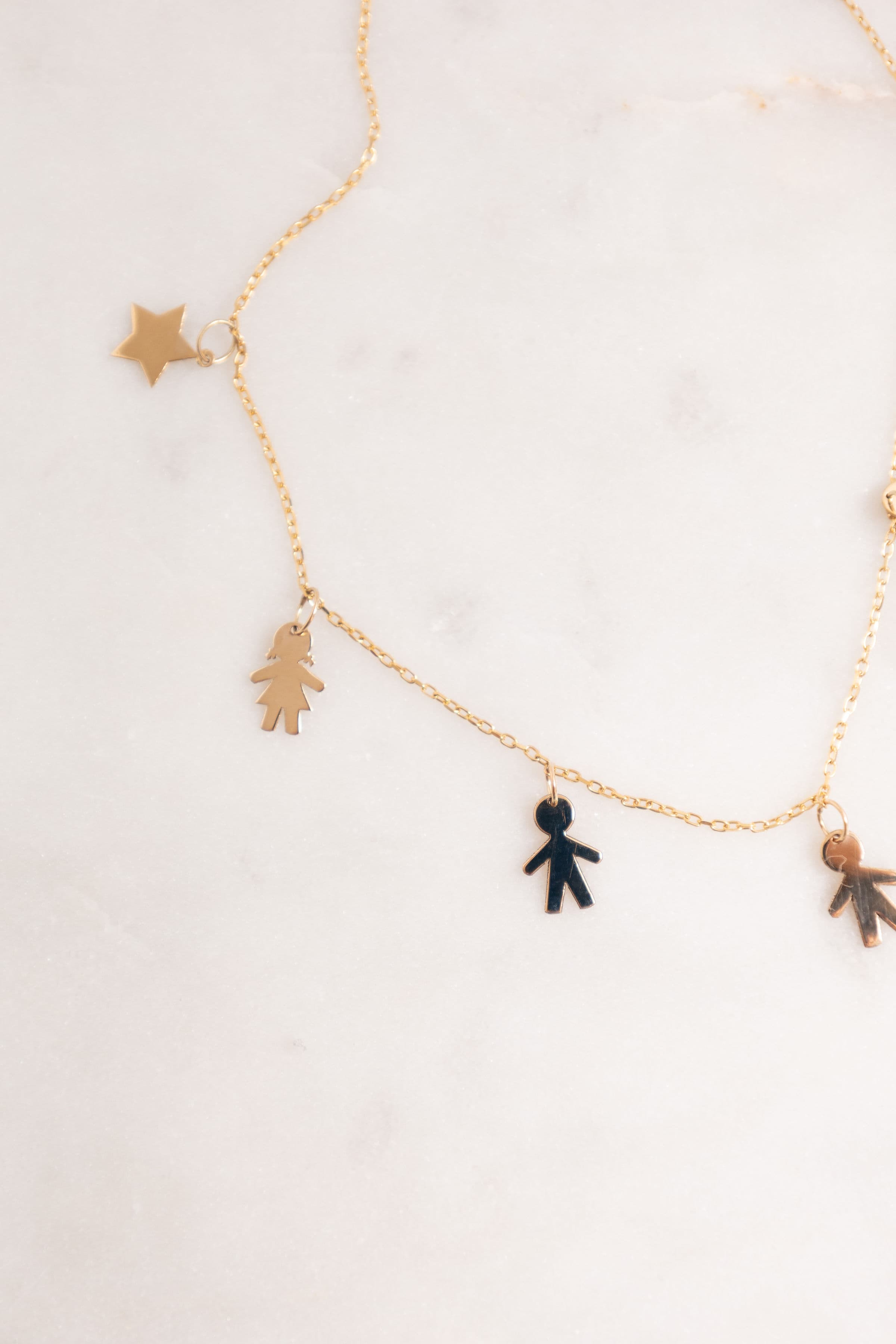 Detalle: estrella, niña, niño y niño en oro