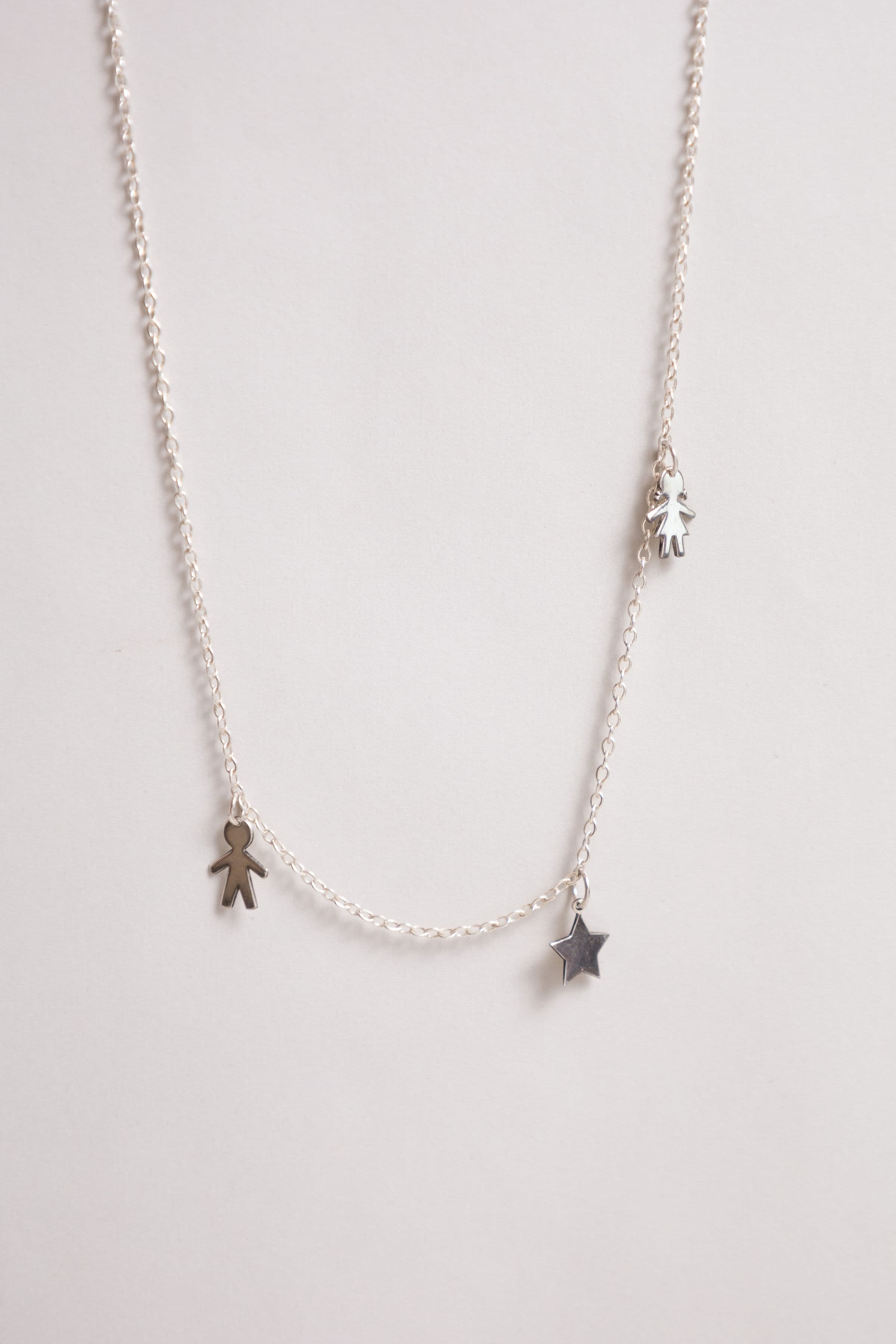 Cadena plata: niño, estrella y niña